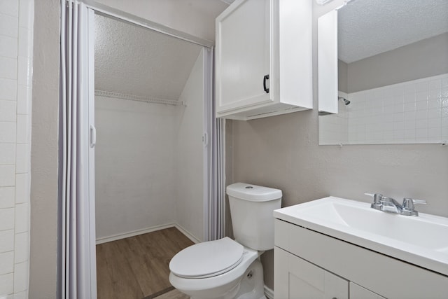 bathroom with vanity, wood-type flooring, a textured ceiling, and toilet