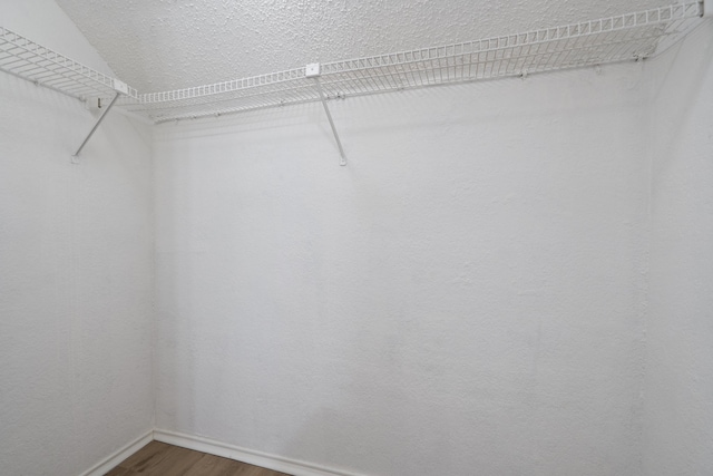 spacious closet featuring hardwood / wood-style flooring and vaulted ceiling