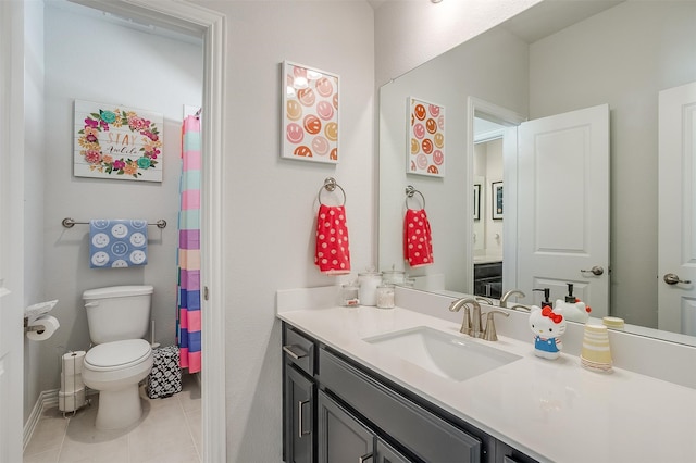 bathroom with toilet, vanity, and tile patterned floors