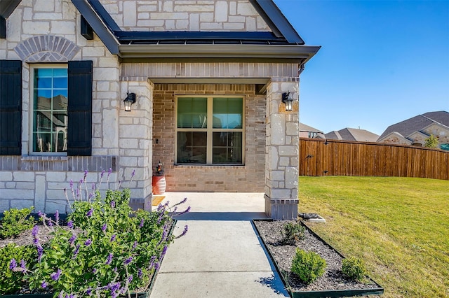 view of exterior entry with a yard