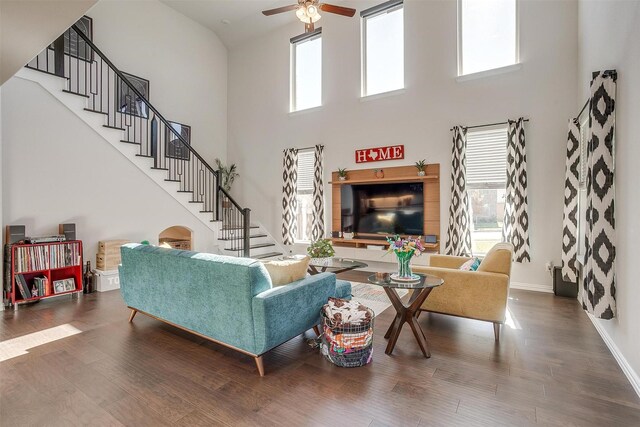 living room featuring hardwood / wood-style floors, a towering ceiling, and ceiling fan