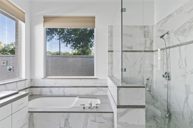 bathroom with vanity, shower with separate bathtub, and a wealth of natural light