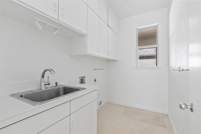 laundry area with electric dryer hookup, cabinets, sink, washer hookup, and light tile patterned floors