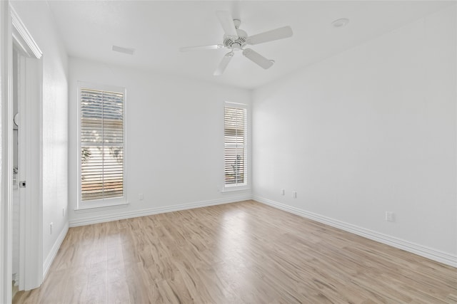 unfurnished room featuring ceiling fan, light hardwood / wood-style floors, and a wealth of natural light