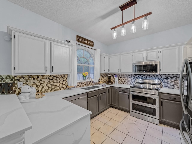 kitchen with decorative backsplash, appliances with stainless steel finishes, a textured ceiling, and pendant lighting