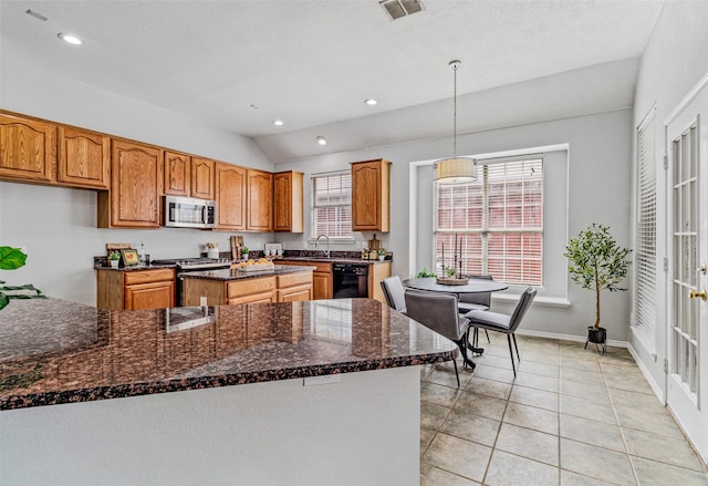 kitchen with pendant lighting, light tile patterned flooring, a wealth of natural light, and vaulted ceiling