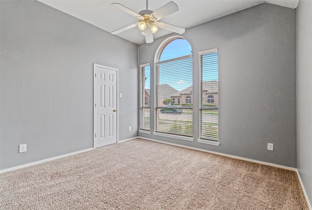 empty room with ceiling fan, carpet floors, and lofted ceiling