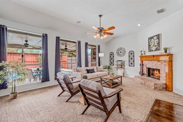 living room featuring a fireplace, plenty of natural light, carpet floors, and vaulted ceiling