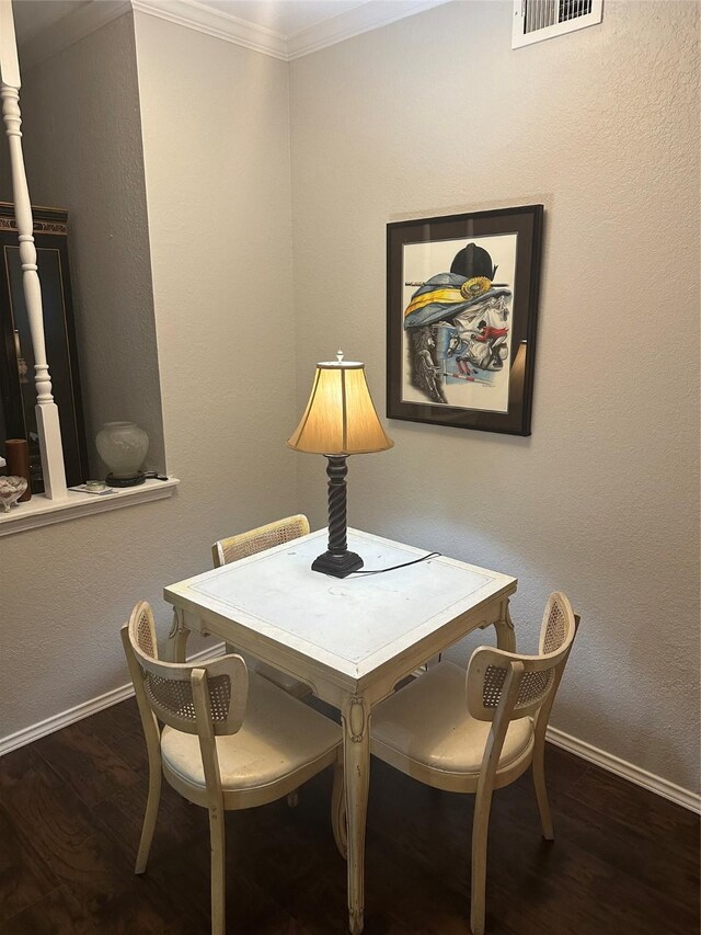 dining area featuring crown molding and dark wood-type flooring