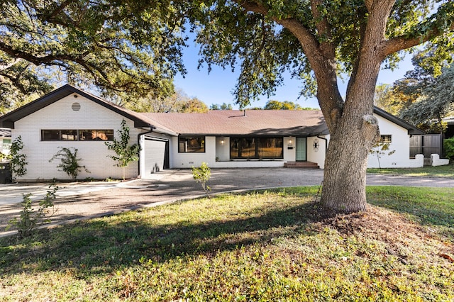 ranch-style house featuring a garage and a front yard