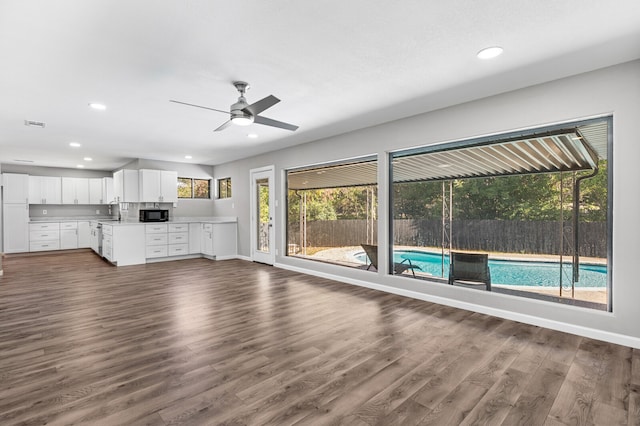 unfurnished living room with dark hardwood / wood-style flooring, ceiling fan, a healthy amount of sunlight, and sink