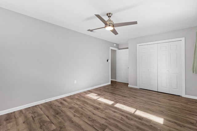 unfurnished bedroom with ceiling fan, a closet, and wood-type flooring