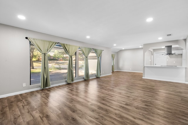 unfurnished living room featuring ceiling fan and dark hardwood / wood-style flooring