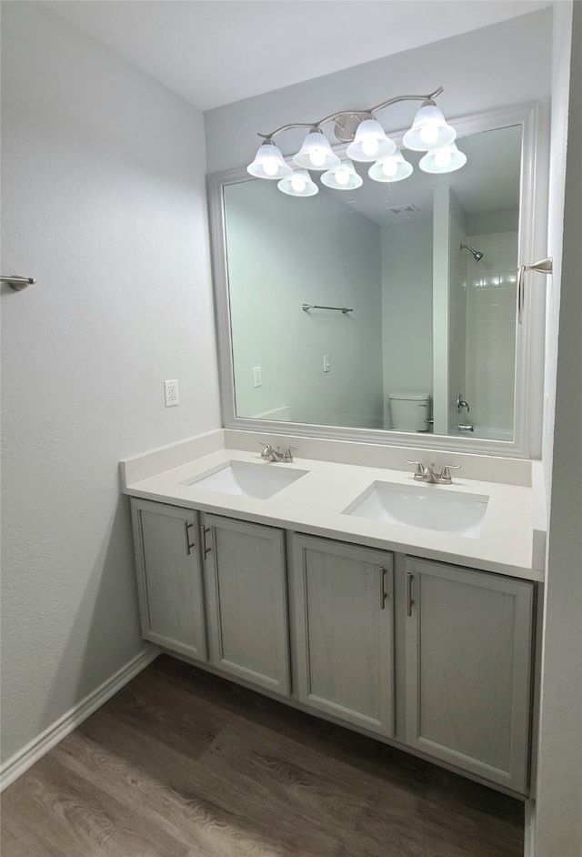 bathroom with a shower, toilet, vanity, and hardwood / wood-style flooring