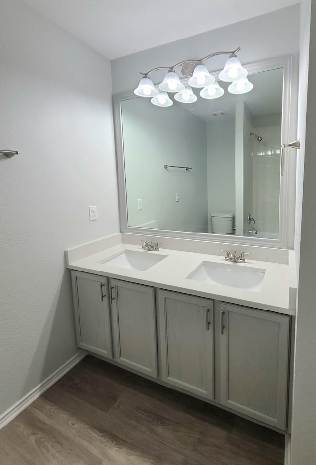 bathroom featuring hardwood / wood-style flooring, vanity, walk in shower, and toilet