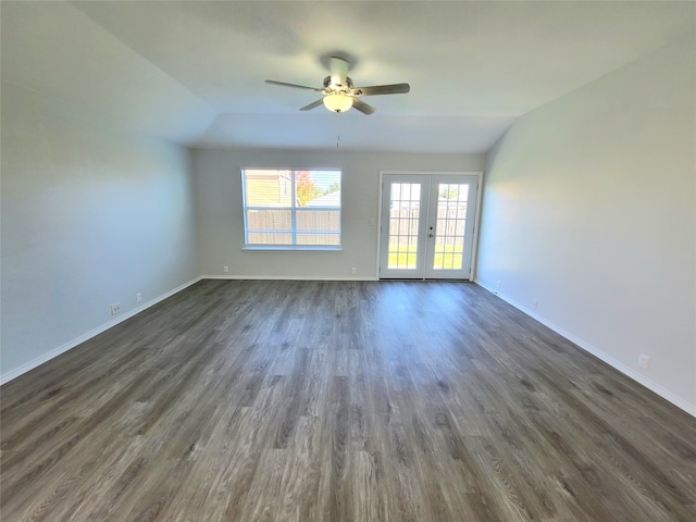 empty room featuring ceiling fan, vaulted ceiling, dark hardwood / wood-style flooring, and french doors