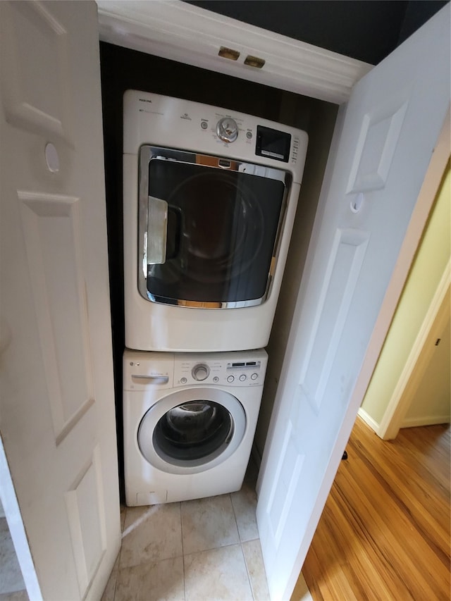 clothes washing area with stacked washer and dryer and light tile patterned floors