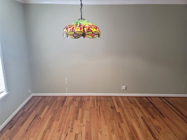 empty room featuring ornamental molding and hardwood / wood-style flooring