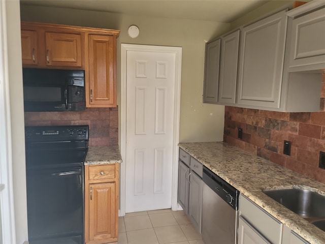 kitchen with dishwasher, backsplash, sink, light stone countertops, and light tile patterned floors