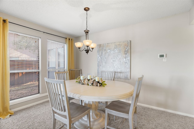 dining space with carpet, a textured ceiling, and a notable chandelier