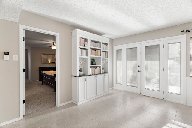 interior space featuring ceiling fan, a textured ceiling, a wealth of natural light, and french doors