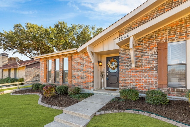 property entrance with a lawn