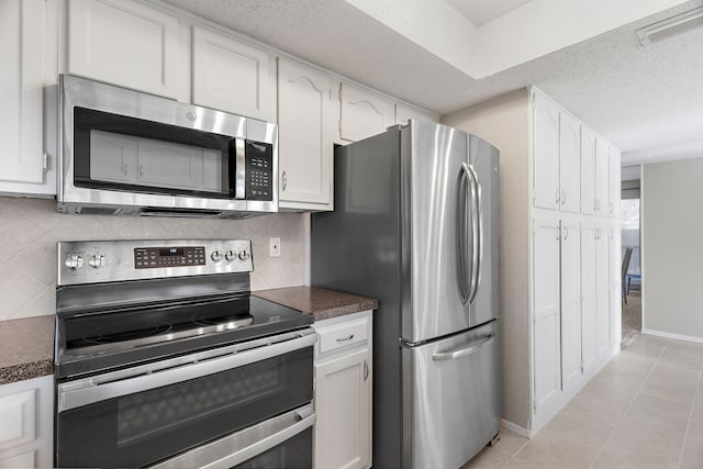 kitchen with backsplash, white cabinets, and appliances with stainless steel finishes