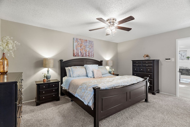 bedroom featuring light carpet, a textured ceiling, and ceiling fan