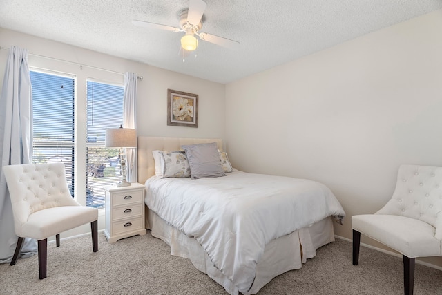 carpeted bedroom featuring a textured ceiling and ceiling fan