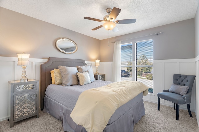 carpeted bedroom with ceiling fan and a textured ceiling