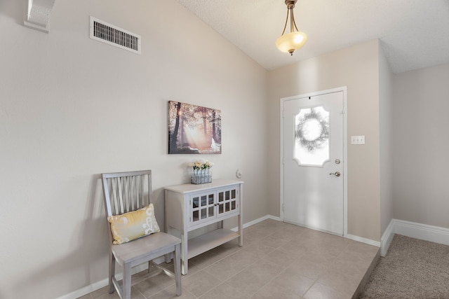 foyer featuring a textured ceiling and lofted ceiling