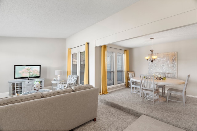 living room featuring light carpet, a textured ceiling, and a notable chandelier