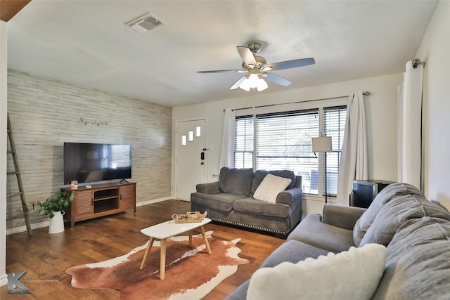 living room featuring ceiling fan and dark hardwood / wood-style flooring