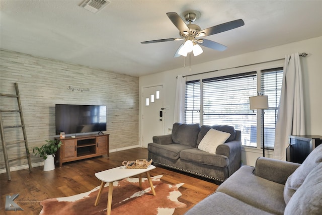 living room featuring a wealth of natural light, ceiling fan, and dark wood-type flooring