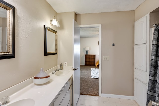 bathroom featuring tile patterned floors, vanity, and a textured ceiling