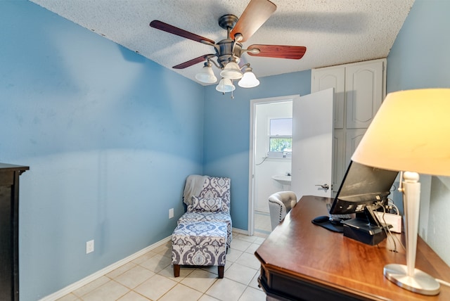 tiled office space with a textured ceiling and ceiling fan