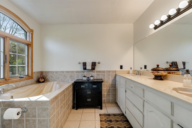 bathroom featuring tile patterned flooring, vanity, tiled bath, and tile walls