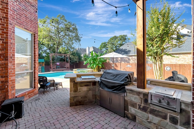 view of patio / terrace featuring grilling area, exterior kitchen, and a pool with hot tub