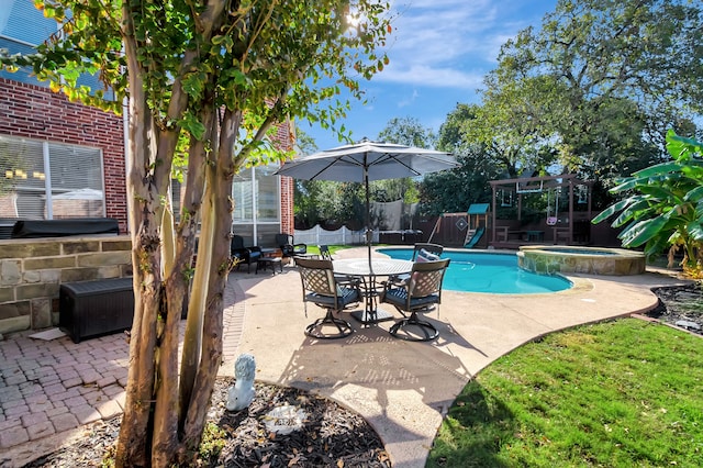 view of swimming pool featuring a patio area, a trampoline, and an in ground hot tub