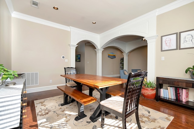 dining area featuring decorative columns, dark hardwood / wood-style flooring, and ornamental molding