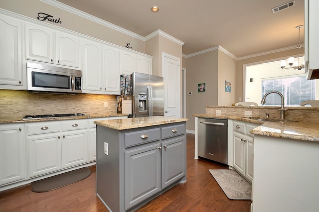 kitchen featuring pendant lighting, gray cabinetry, appliances with stainless steel finishes, a kitchen island, and white cabinetry