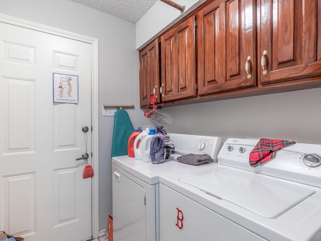 laundry area featuring cabinets, a textured ceiling, and washing machine and clothes dryer