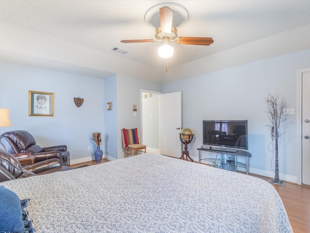 bedroom featuring ceiling fan, light hardwood / wood-style flooring, and a textured ceiling