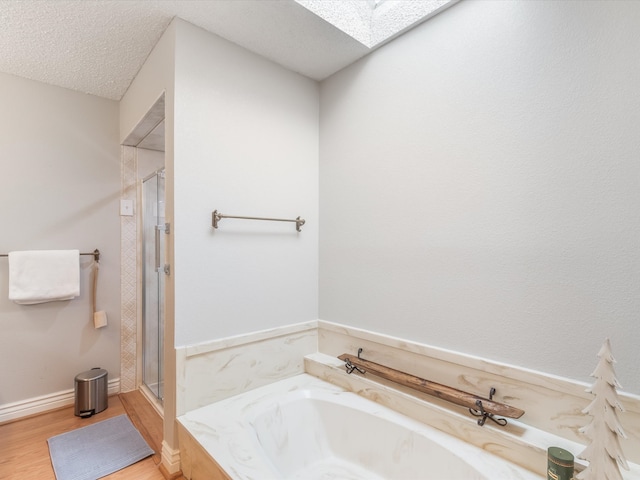 bathroom featuring hardwood / wood-style floors, a textured ceiling, and shower with separate bathtub