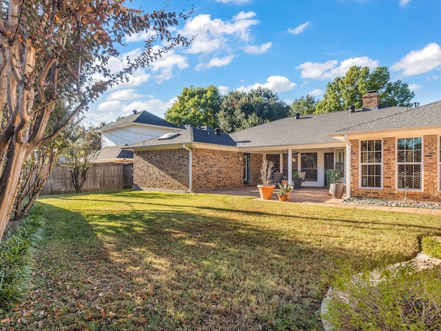 back of house with a lawn and a patio area