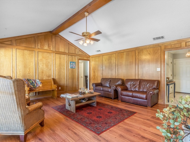 living room with vaulted ceiling with beams, wooden walls, ceiling fan, and hardwood / wood-style flooring