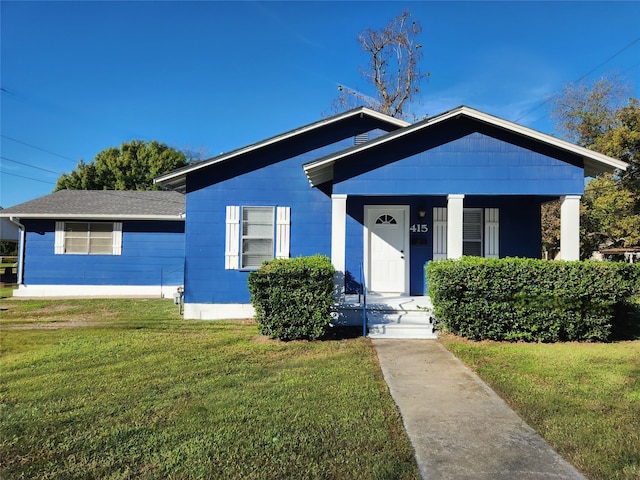 bungalow-style home with a front lawn and covered porch