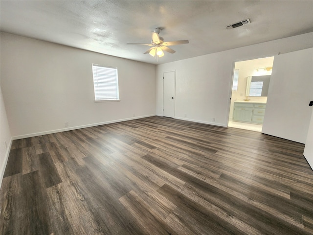 unfurnished room with a textured ceiling, dark hardwood / wood-style flooring, and ceiling fan