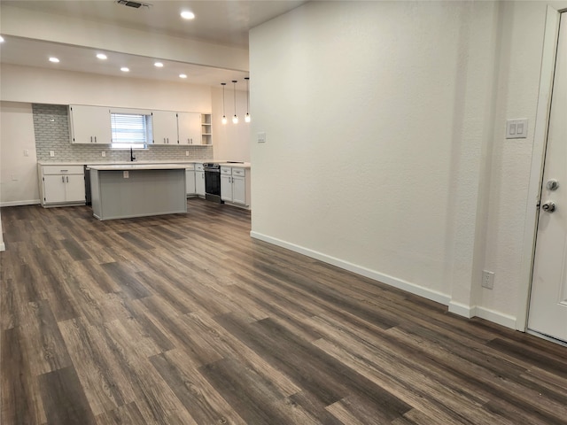 kitchen featuring decorative light fixtures, white cabinetry, dark hardwood / wood-style floors, and a kitchen island