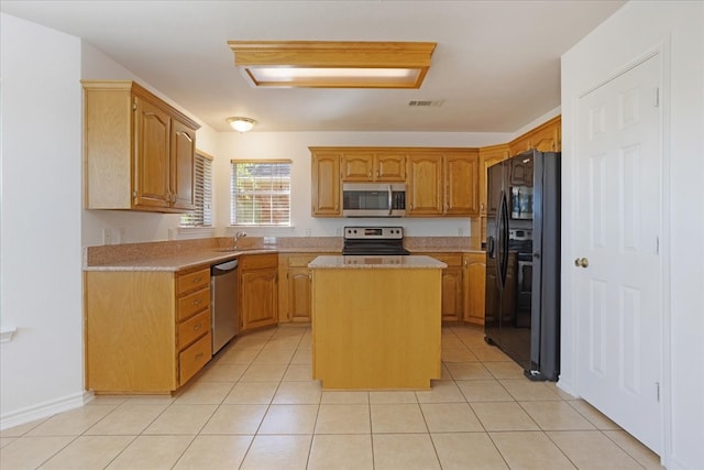 kitchen featuring a center island, light tile patterned flooring, sink, and appliances with stainless steel finishes